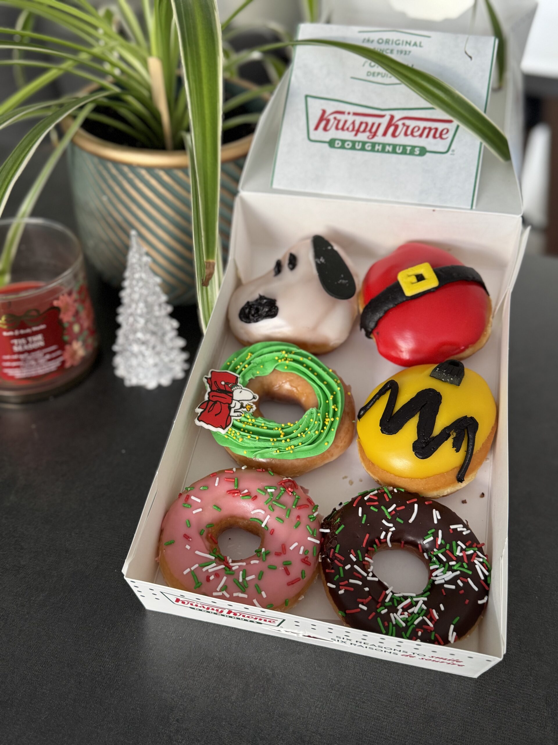 Beignes de l’édition spéciale Krispy Kreme x Peanuts, incluant Snoopy, Charlie Brown et des créations festives aux couleurs de Noël.