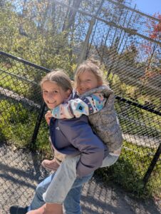 Famille marchant parmi les sentiers du Miller Zoo, entourée d’animaux et de nature