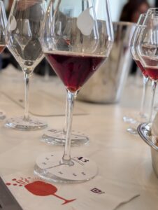 Plusieurs verres de vin blanc et rouge alignés sur une table lors d'une dégustation de l'agence A3.