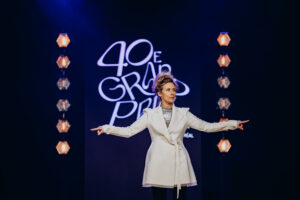 L'animatrice Édith Cochrane sur la scène du Palais des congrès pour le 40e Grand Prix du Conseil des arts de Montréal, entourée des lauréats de la soirée.