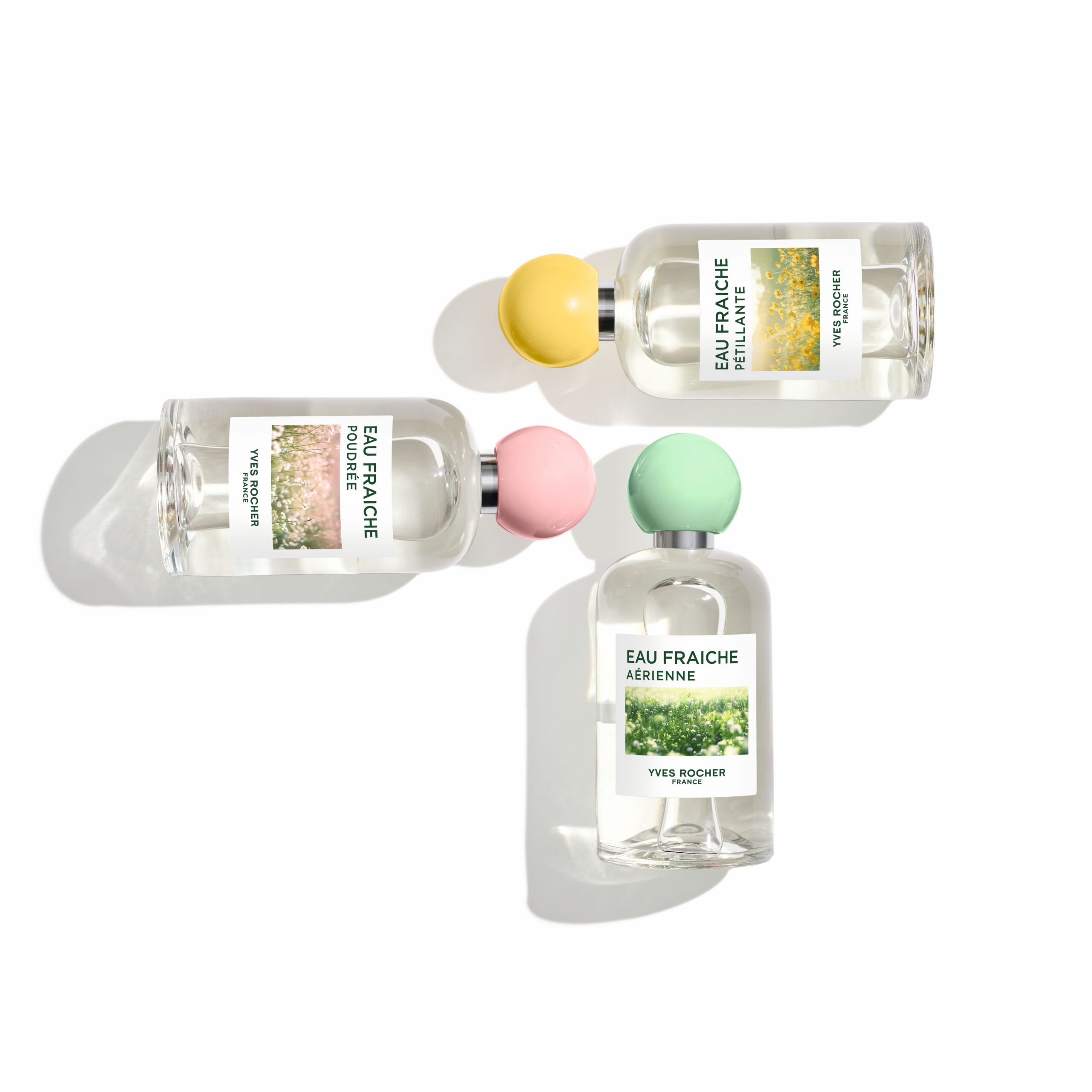 Flacons des nouvelles fragrances Eaux Fraîches d' Yves Rocher entourés de délicates fleurs printanières