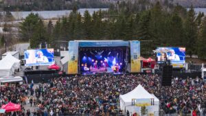 Outdoor music festival with a large stage labeled BLOOMAFEST Tremblant and a dense crowd in front of it.