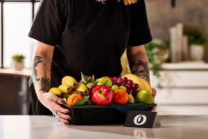 Un magnifique panier de fruits frais et colorés de Fruit O Bureau posé sur une table