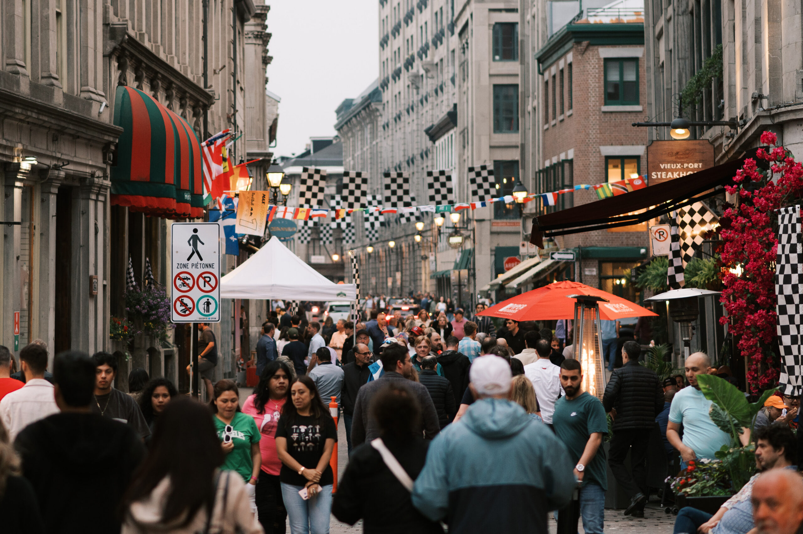 Foule élégante profitant d'une terrasse animée et de la gastronomie dans le Vieux-Montréal pendant les festivités du Grand Prix.