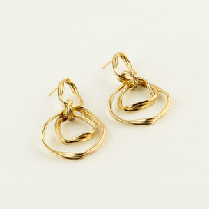 Intertwined gold wire jewelry resting on a pale background, photographed close up.