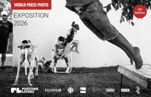World Press Photo Exposition 2016 banner with children playing, a dog, and sponsors logos along the bottom.