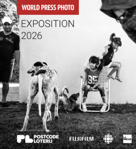 World Press Photo Exposition 2016 banner with children playing, a dog, and sponsors logos along the bottom.