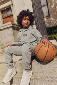 Enfant souriant qui porte un chandail de la nouvelle collection automne Campus de Miles The Label.