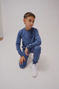 Enfant souriant qui porte un chandail de la nouvelle collection automne Campus de Miles The Label.